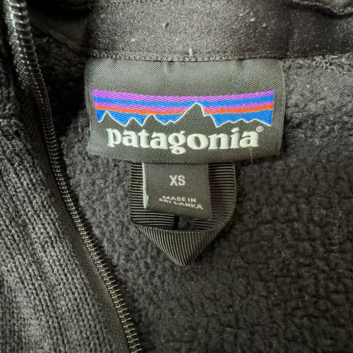 Patagonia black recycled polyester zip-up hoodie back view on model, showing fitted silhouette and side pockets