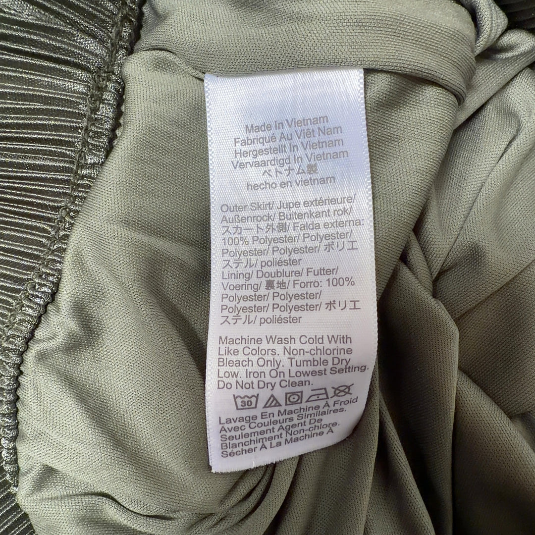 Tag view of green pleated midi skirt showing the elegant drape and length of the pleated design