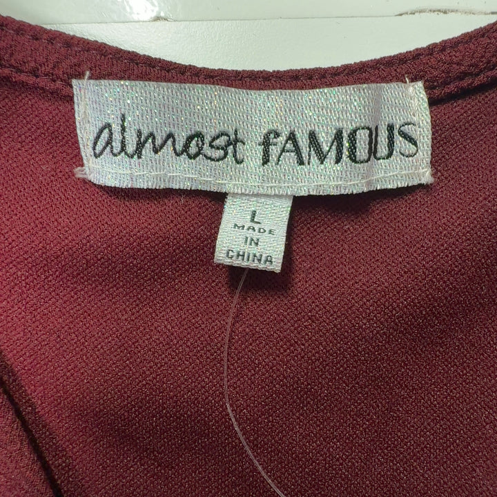 Burgundy wrap short sleeve dress with black asymmetrical trim detail, back view