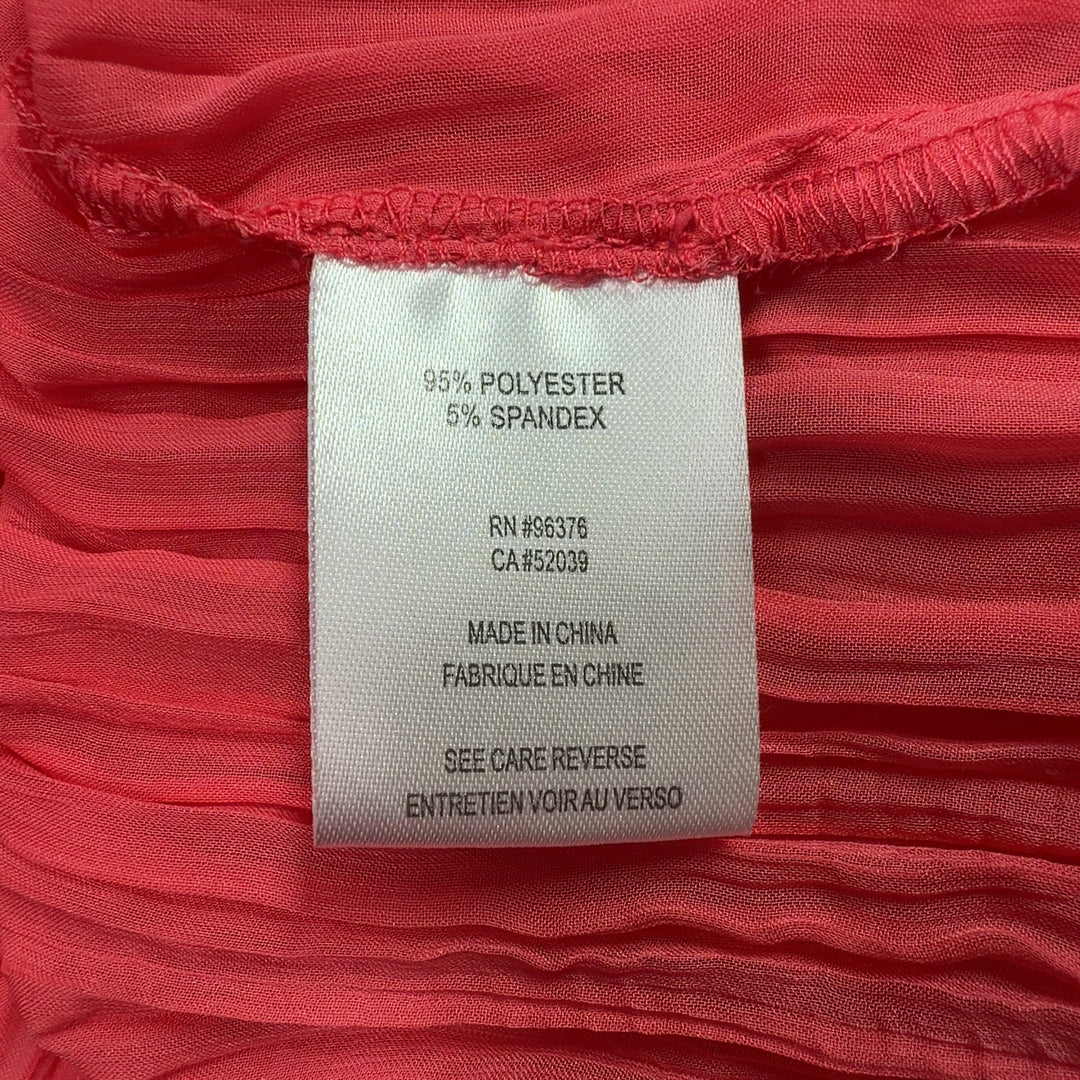Tag view of red pleated long sleeve top showing pleated detailing and relaxed fit