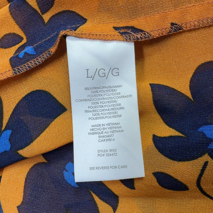 Navy and orange floral Cabi blouse with geometric patterned bell sleeves, back view on model