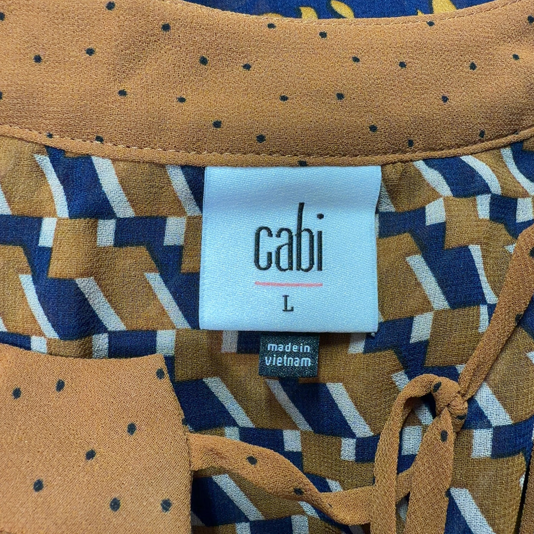 Navy and orange floral Cabi blouse with geometric patterned bell sleeves, back view on model