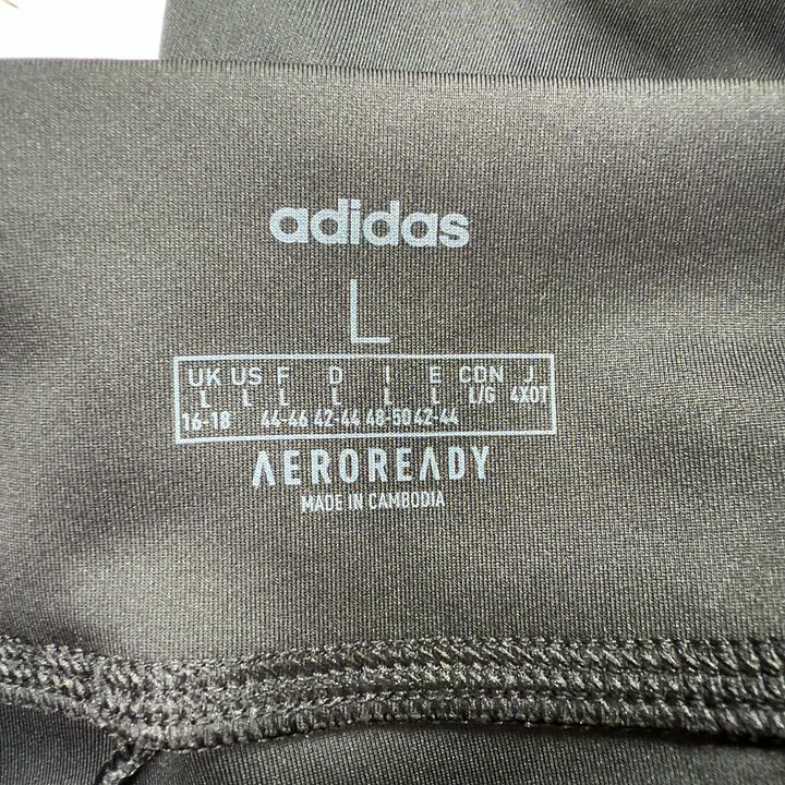Adidas black colorblock leggings back view displaying Adidas branding on lower leg and colorblock paneling detail