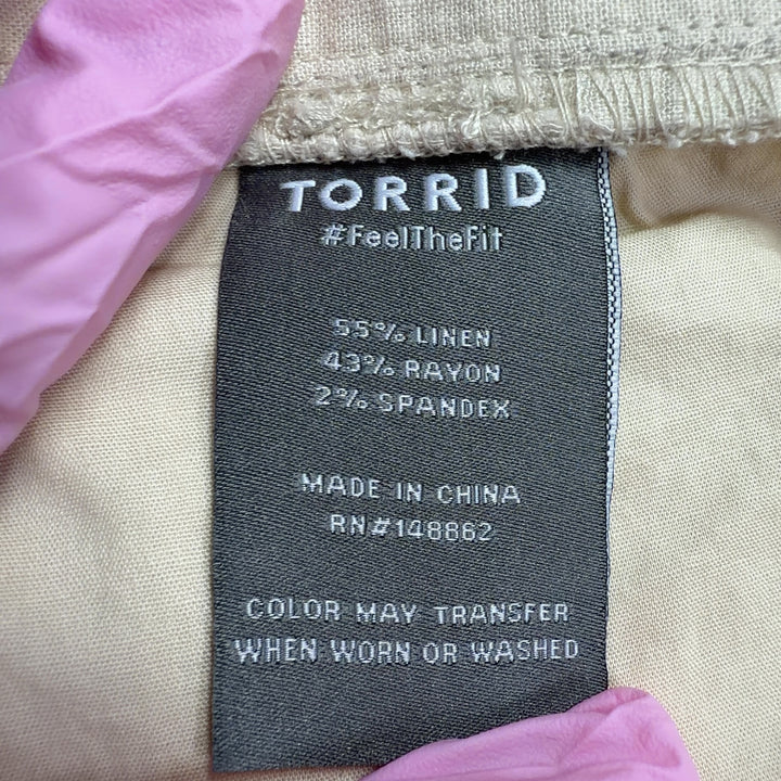 Tag view of cream linen wide-leg cropped pants showing relaxed fit and functional pockets