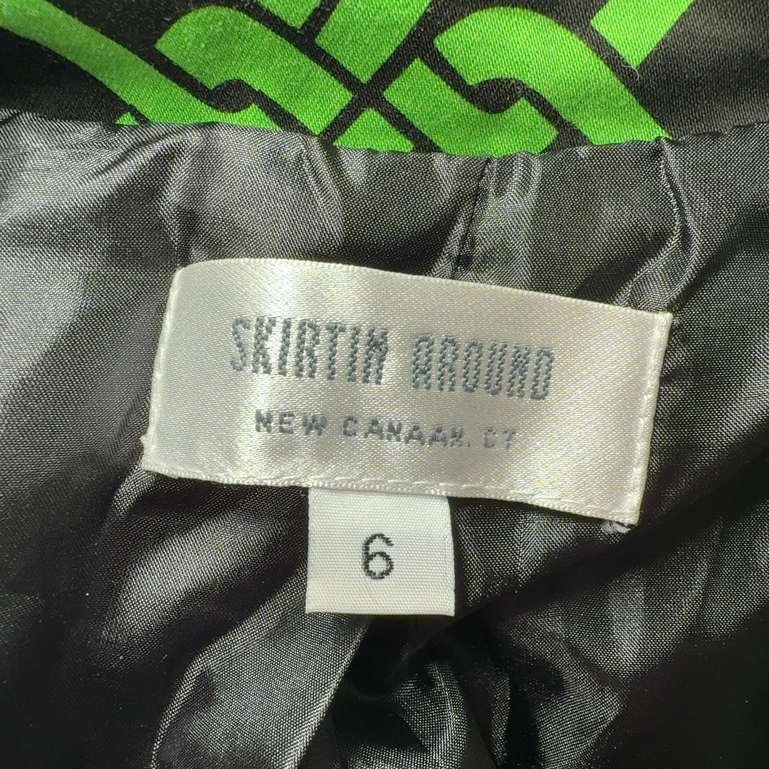 Tag view of green geometric patterned jacket by Skirtin Around showing the full length and drape of the tailored design