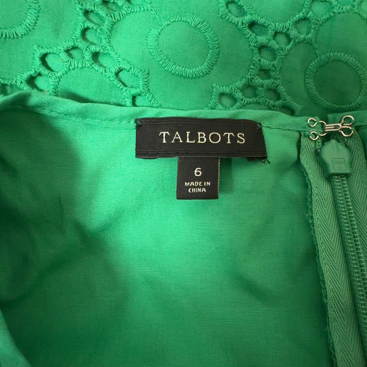 Tag view of green eyelet lace A-line dress showing relaxed fit and midi length