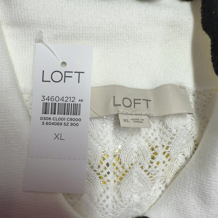 Cream cable knit cardigan with black contrast trim, back view