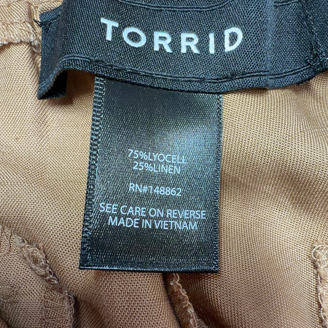 Tag view of camel cargo pants showing cropped ankle length and rear pocket details