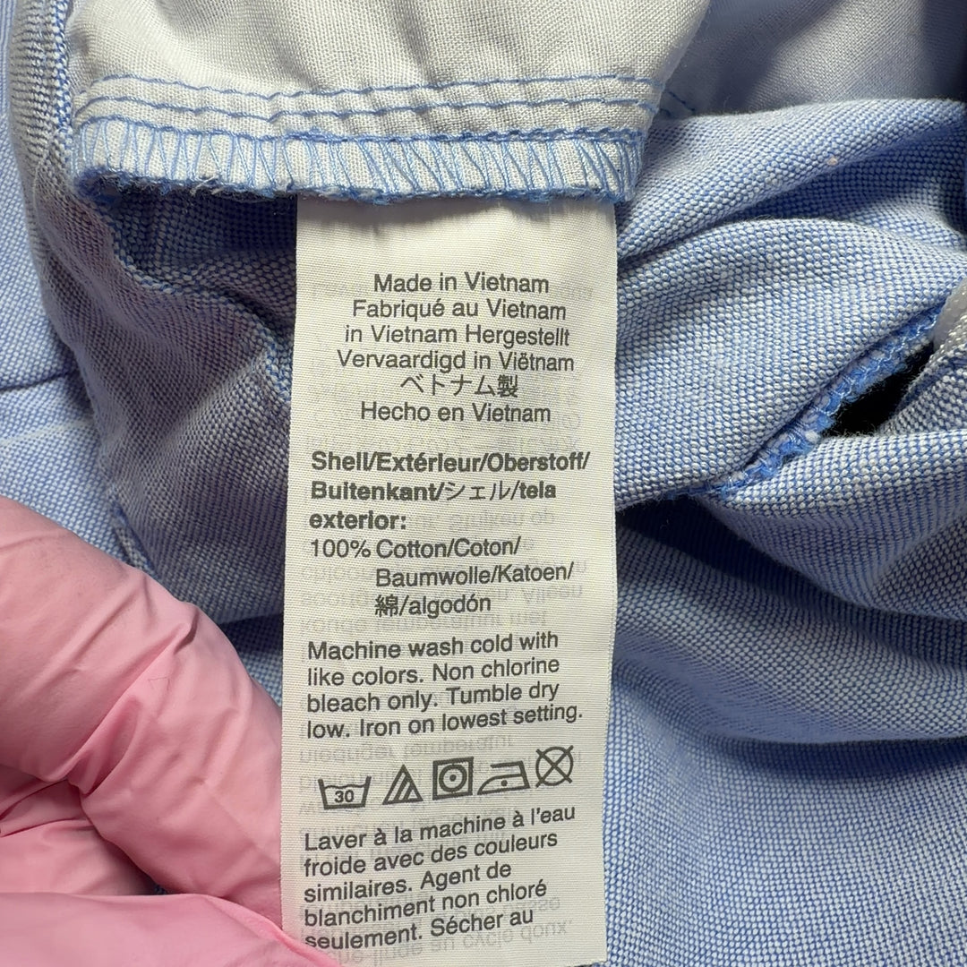 Tag view of light blue cotton Bermuda shorts from J.Crew, size M, showing the traditional button-fly closure and relaxed silhouette