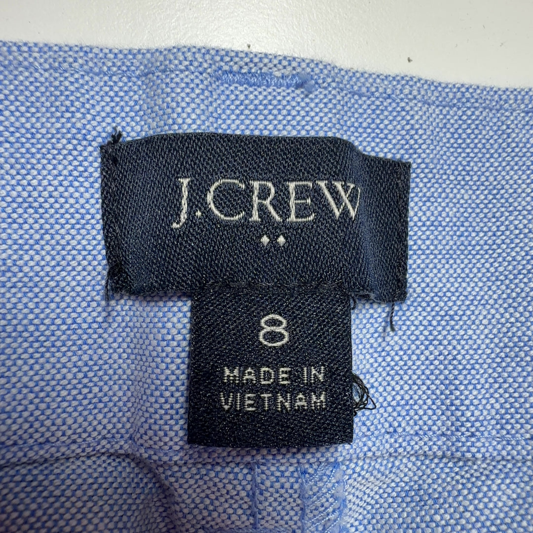 Tag view of light blue cotton Bermuda shorts from J.Crew, size M, showing the traditional button-fly closure and relaxed silhouette