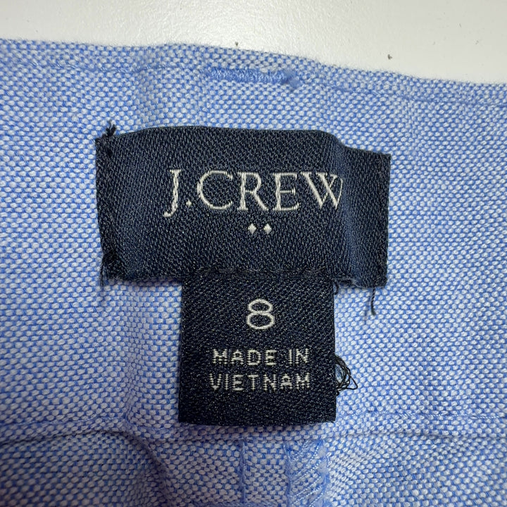 Tag view of light blue cotton Bermuda shorts from J.Crew, size M, showing the traditional button-fly closure and relaxed silhouette