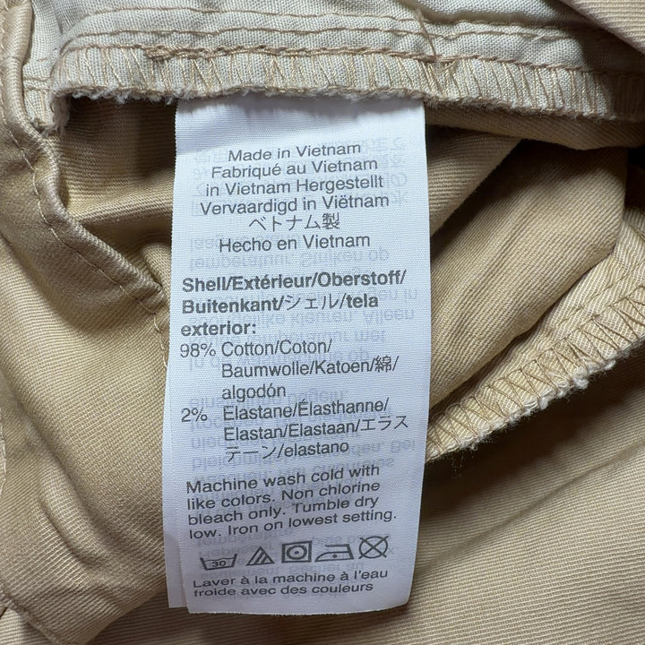Tag view of beige cotton Bermuda shorts showing rear pockets and knee-length cut