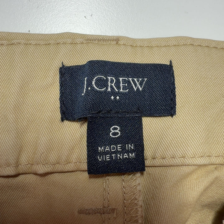 Tag view of beige cotton Bermuda shorts showing rear pockets and knee-length cut