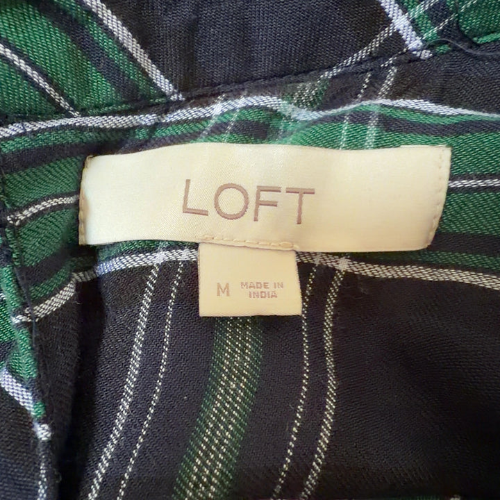 Tag view of green and black plaid rayon long sleeve top showing full plaid pattern and relaxed fit
