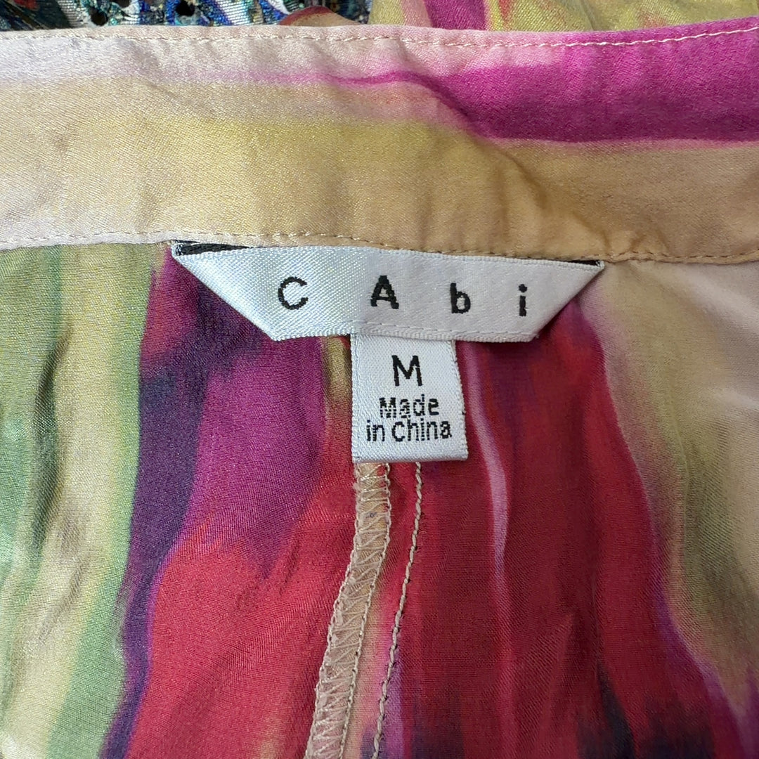 Tag view of multicolor silk ikat print pants showing tapered silhouette and elastic waistband with tie detail