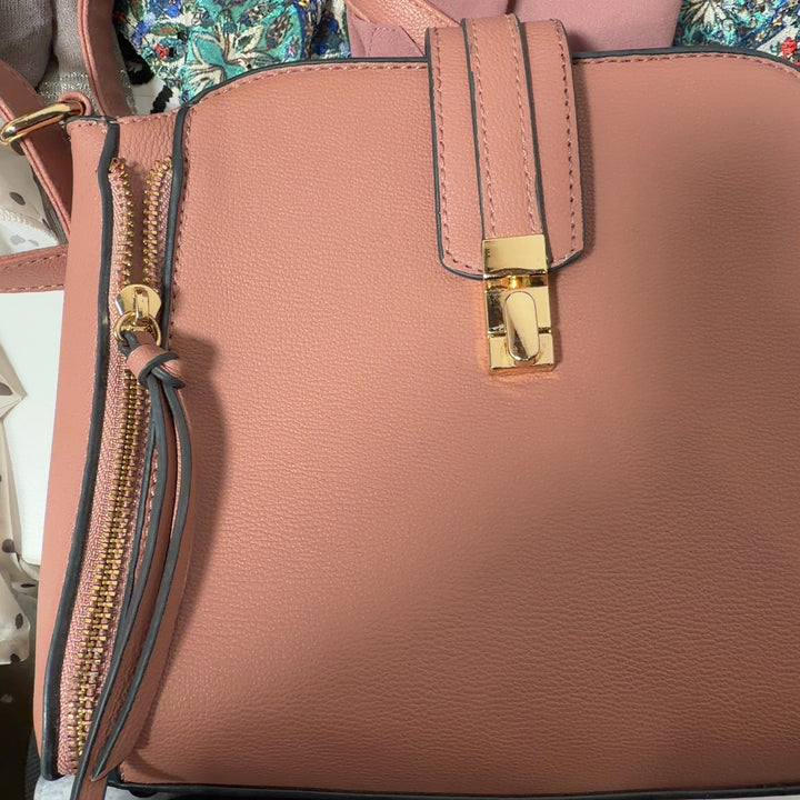 Tag view of tan SilkRoll crossbody bag worn across body showing padlock closure and side zip details