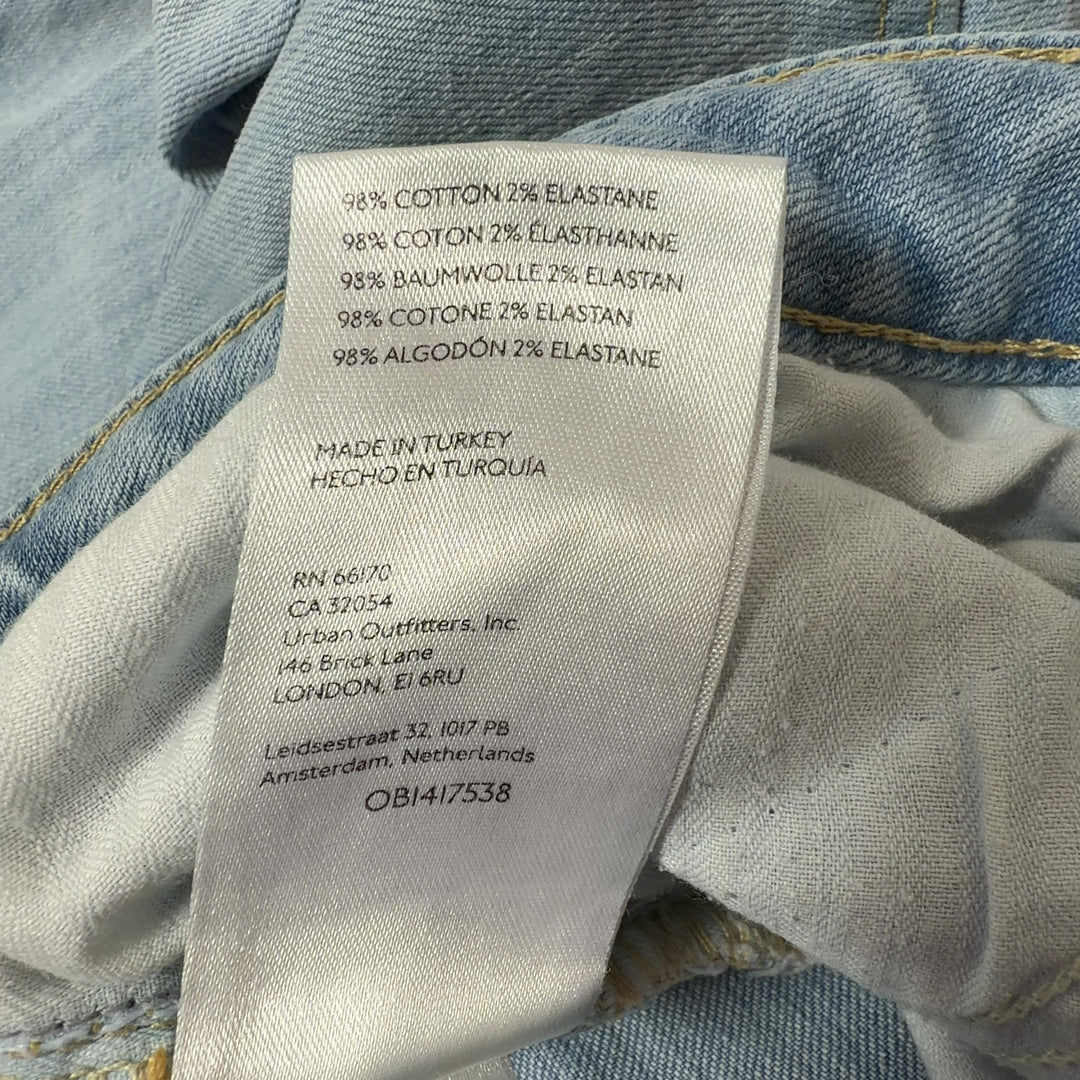 Tag view of light blue denim flare jeans by WE THE FREE, size M, showing flare silhouette and five-pocket construction