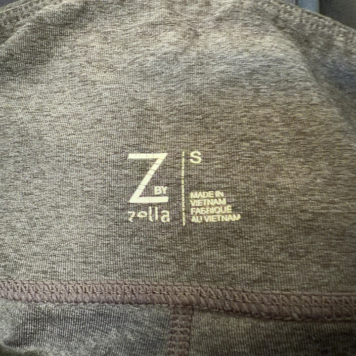 Tag view of charcoal capri leggings showing mesh panel details on calves