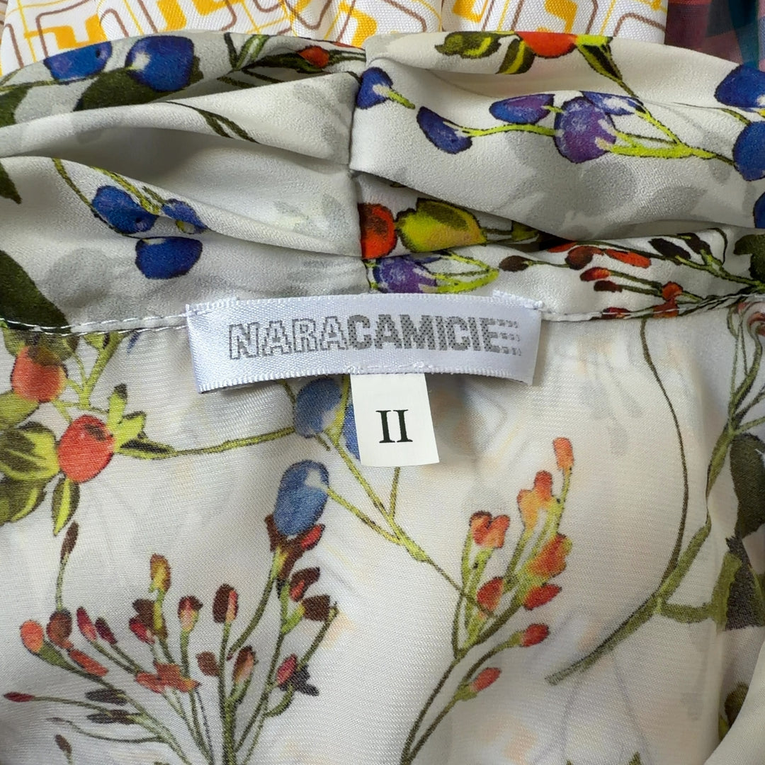 Tag view of cream floral blouse showing full botanical print pattern and tailored fit