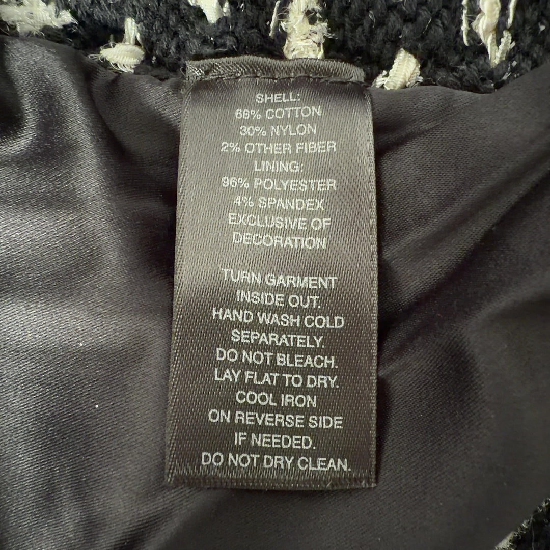 Black studded cropped jacket with geometric stud pattern, back view on model
