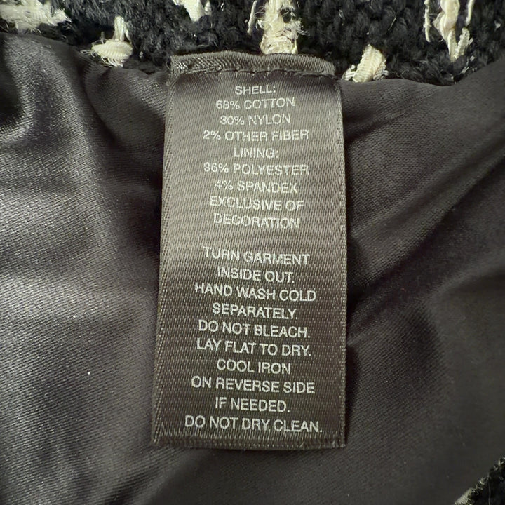 Black studded cropped jacket with geometric stud pattern, back view on model