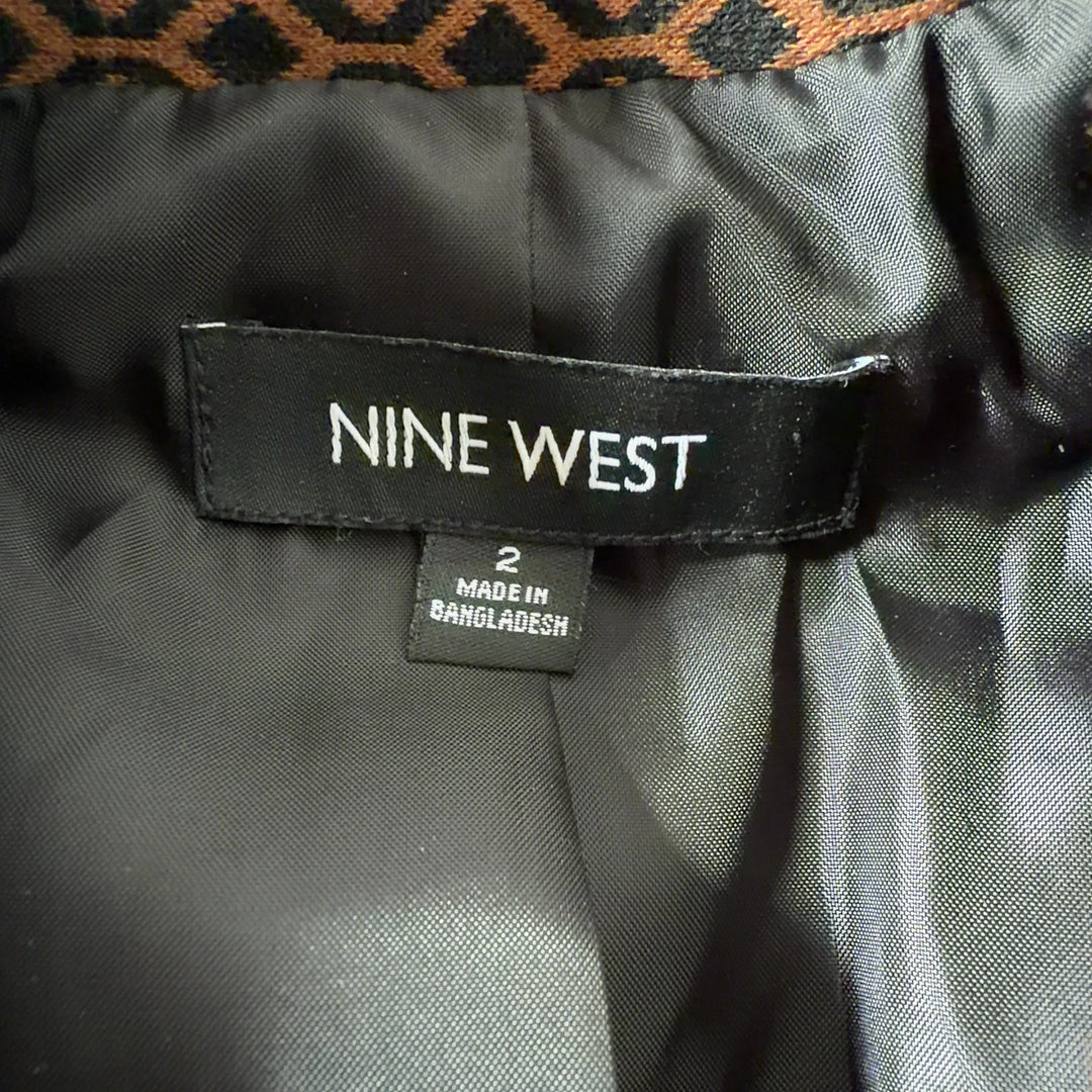 Brown geometric patterned Nine West blazer jacket with black trim, back view on model wearing black pants
