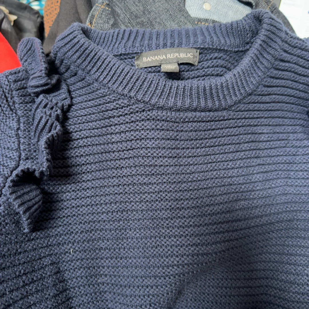 Navy ruffle shoulder knit sweater back view on model, showing textured knit and ruffle details