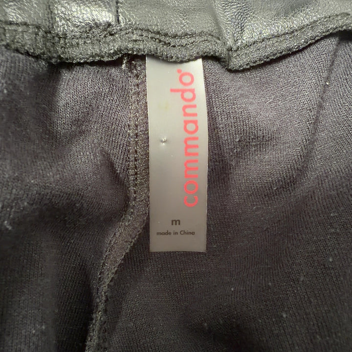 Black leather jogger pants with functional pockets, back view on model