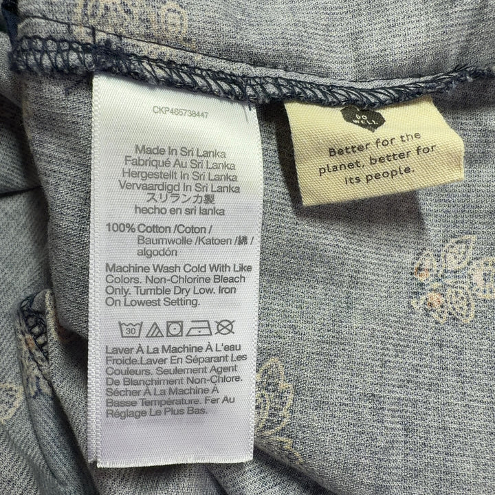 Tag view of navy floral shorts showing relaxed fit and button-front closure detail