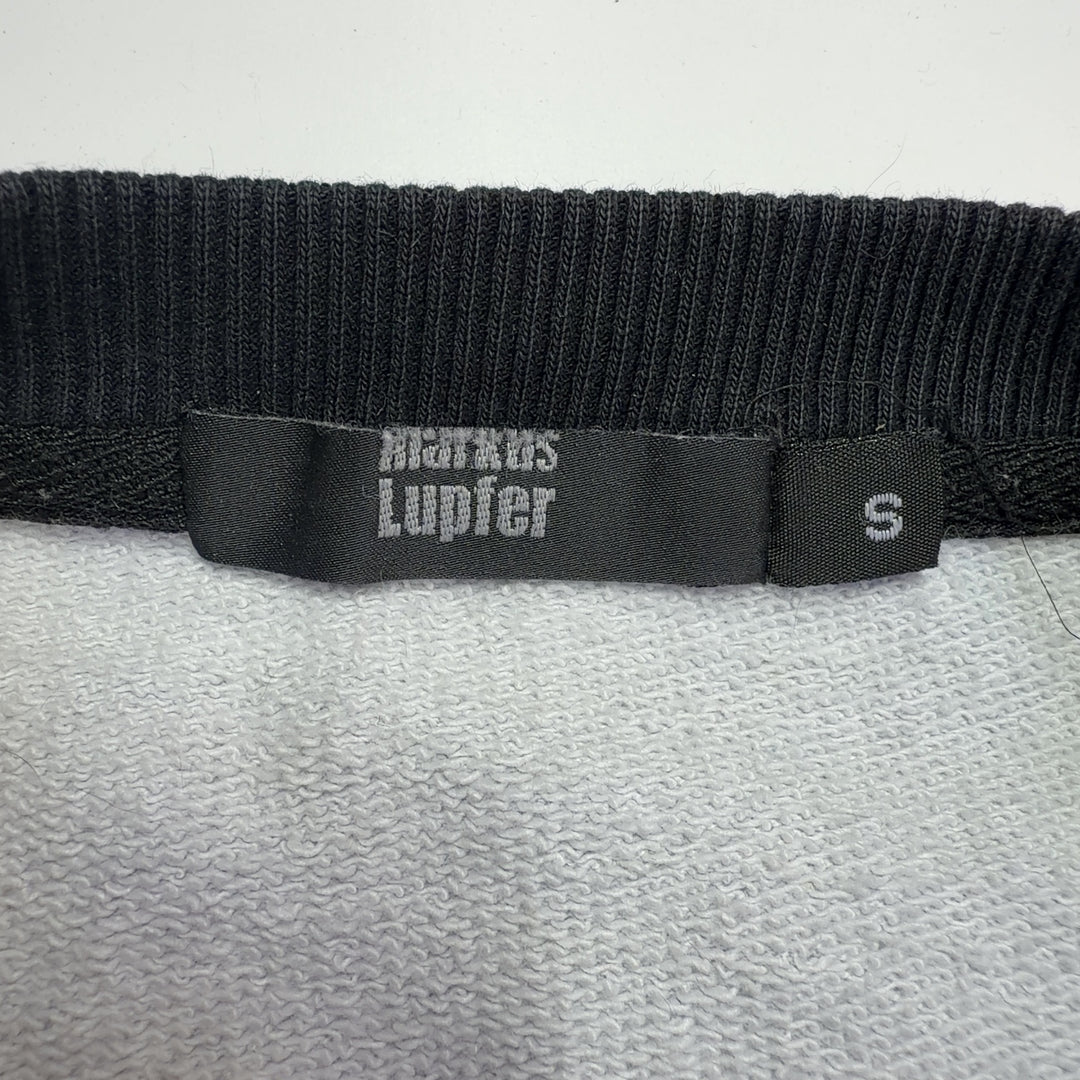 Blue cotton sweatshirt with black and white rose print and black ribbed cuffs, back view