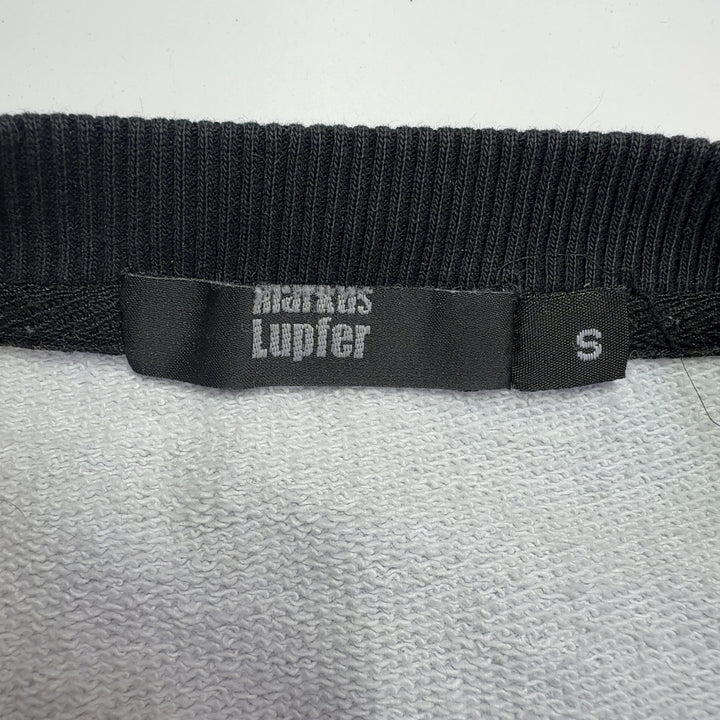 Blue cotton sweatshirt with black and white rose print and black ribbed cuffs, back view