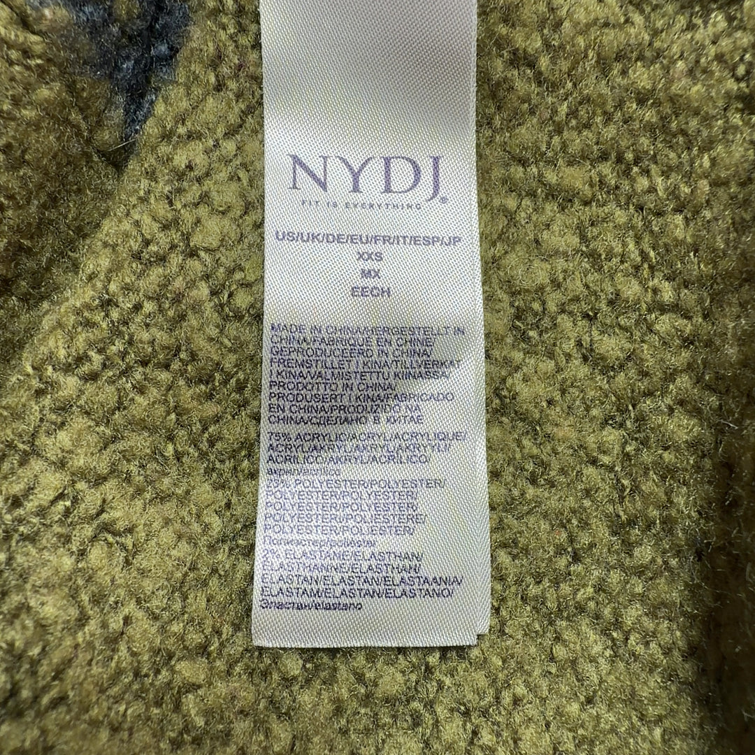 Tag view of olive Fair Isle cardigan showing patterned shoulders and cropped length, styled with black pants and gold heels