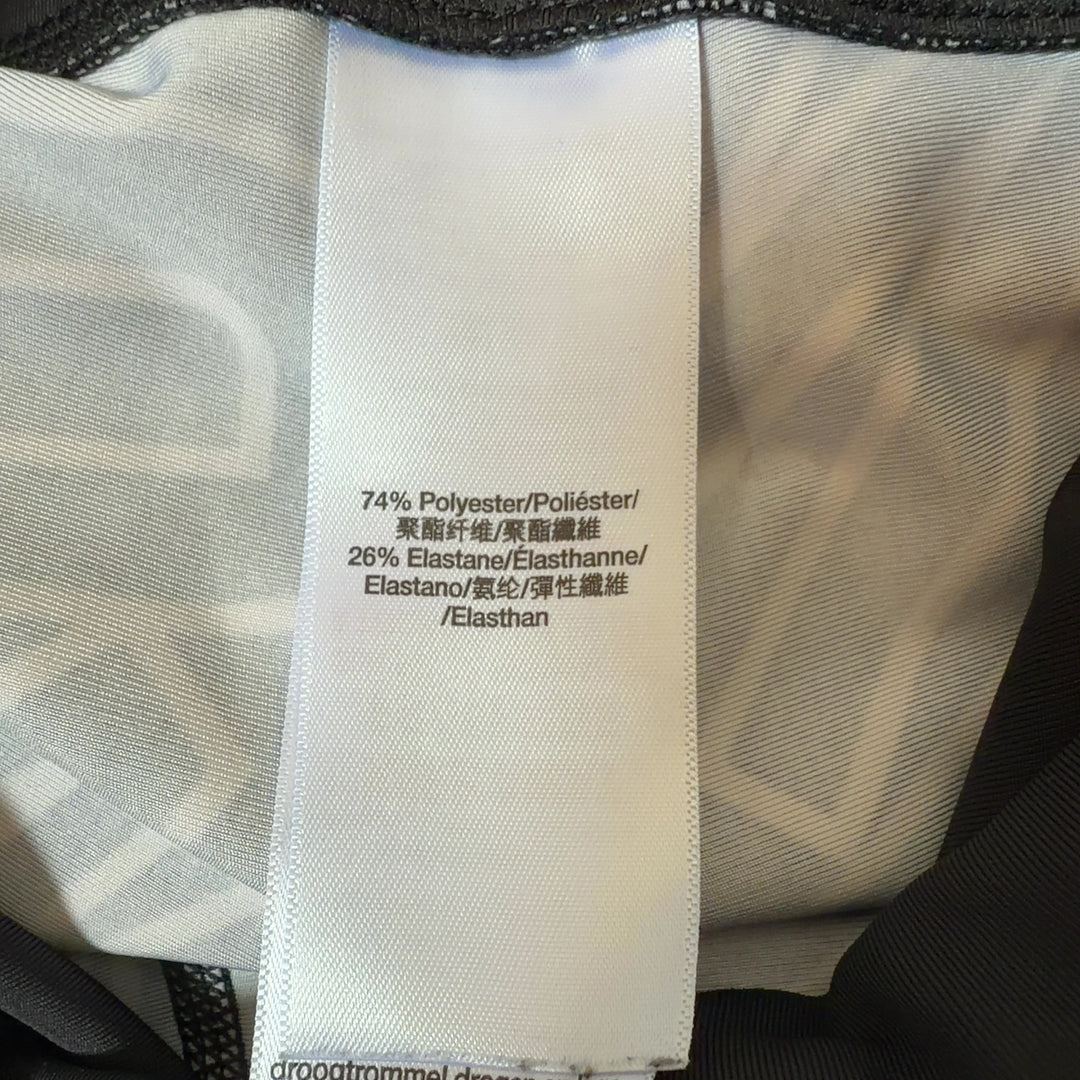 Black and white geometric print DKNY Sport leggings back view, showing side stripe detail and form-fitting silhouette