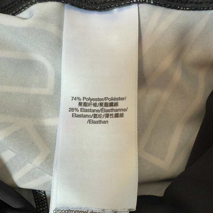 Black and white geometric print DKNY Sport leggings back view, showing side stripe detail and form-fitting silhouette