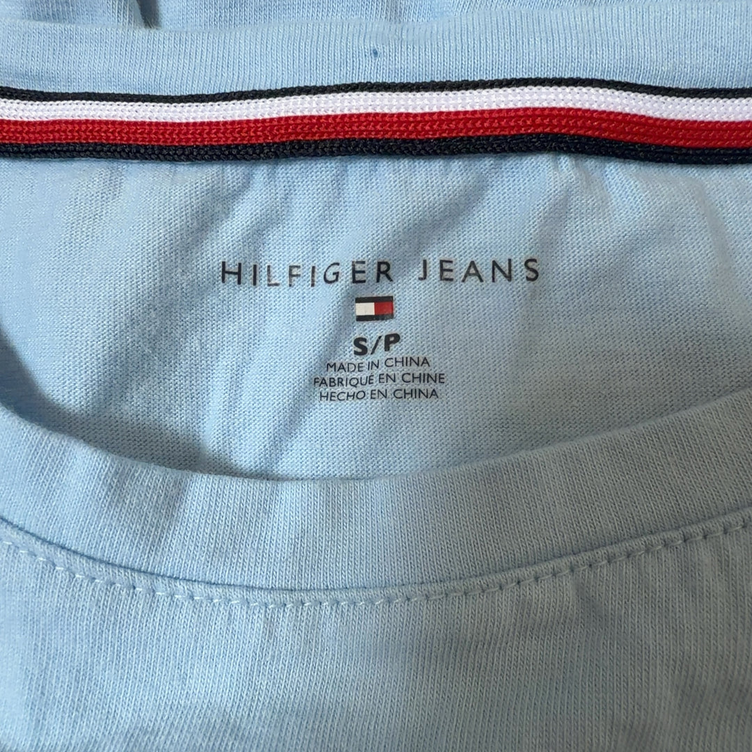 Tag view of light blue Hilfiger Jeans tee showing colorblock logo print and relaxed fit silhouette