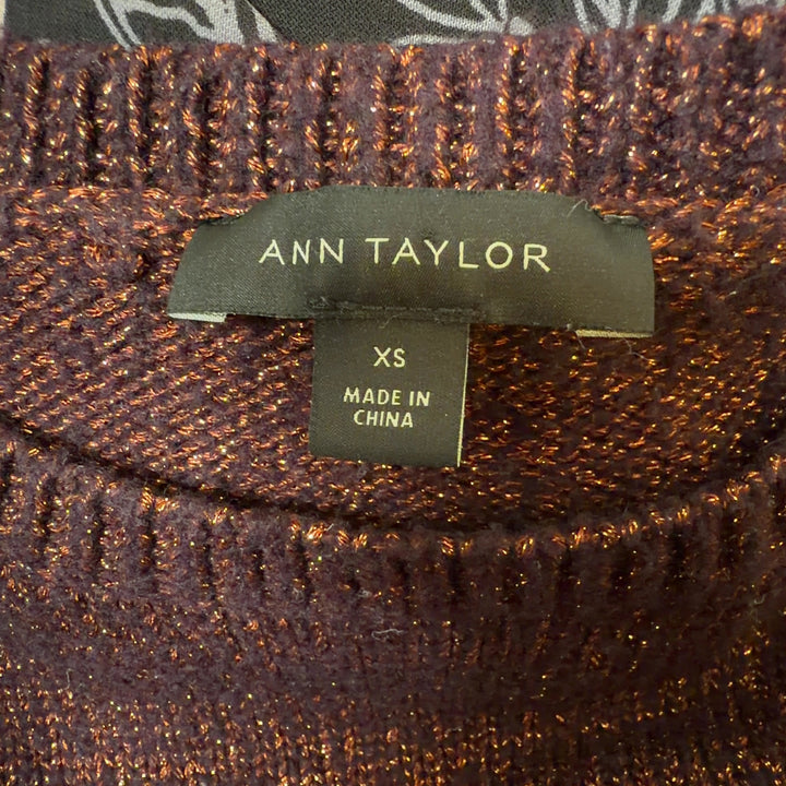 Tag view of burgundy metallic knit pullover sweater showing cropped length and fitted silhouette