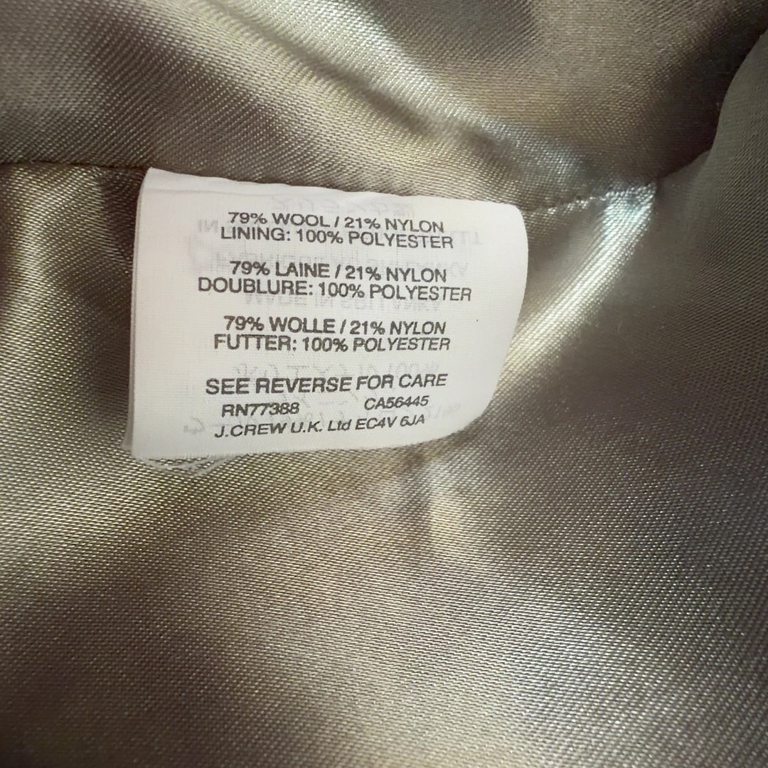 Tag view of cream wool hooded coat showing full-length zip closure and relaxed silhouette