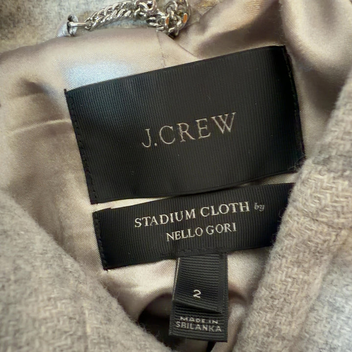 Tag view of cream wool hooded coat showing full-length zip closure and relaxed silhouette