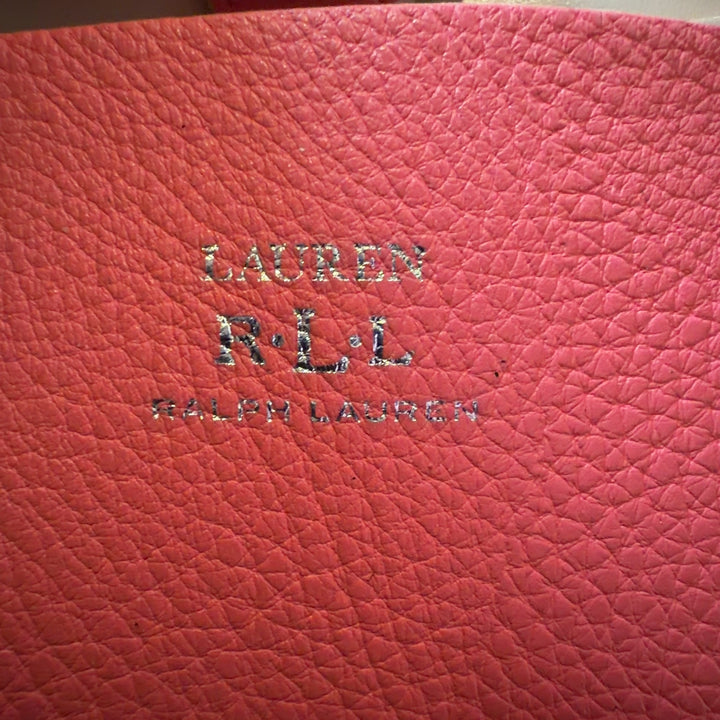 Tag view of pink Lauren Ralph Lauren tote bag worn on shoulder, showing structured silhouette and design details
