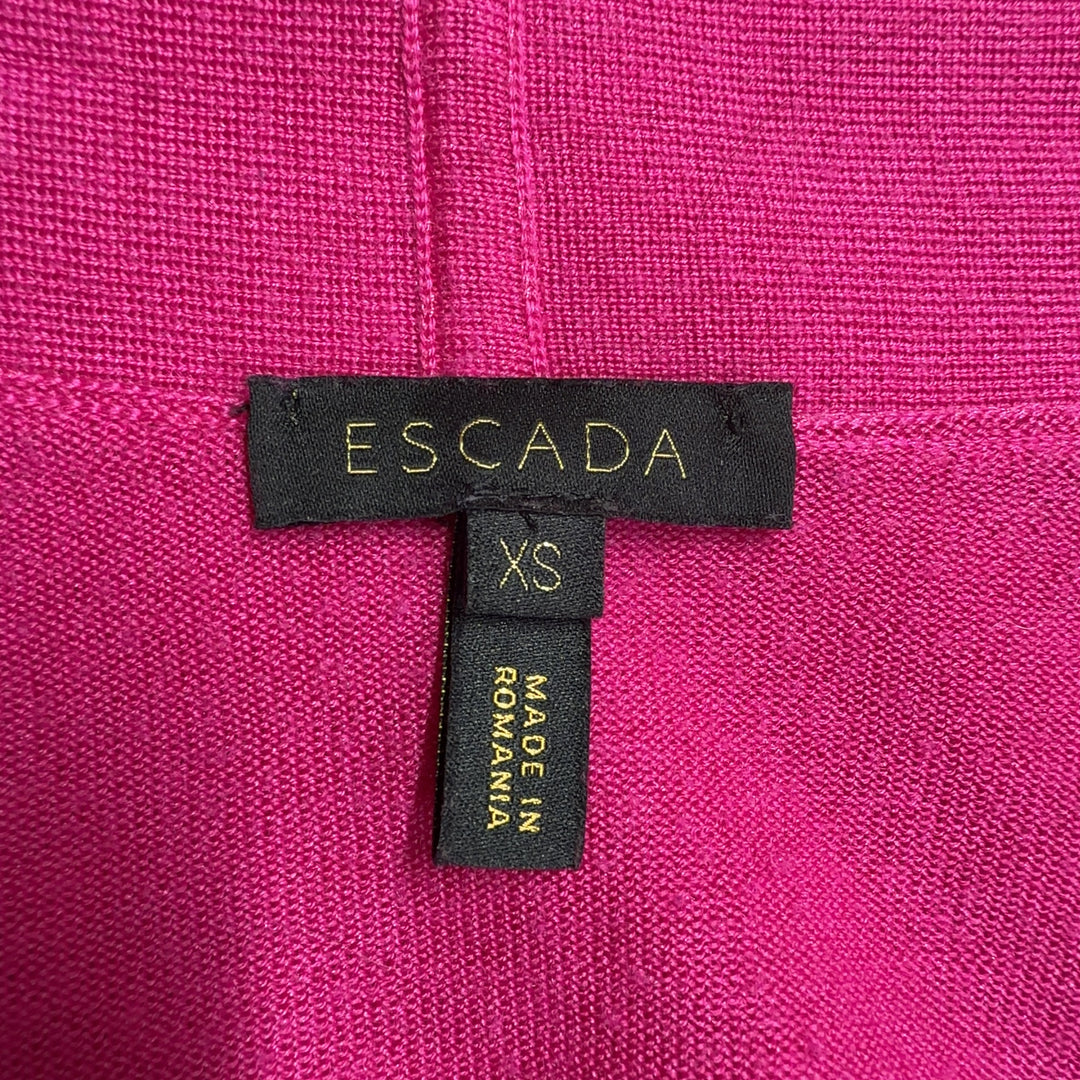 Tag view of pink ESCADA cardigan with long sleeves and flowing silhouette, styled with black pants