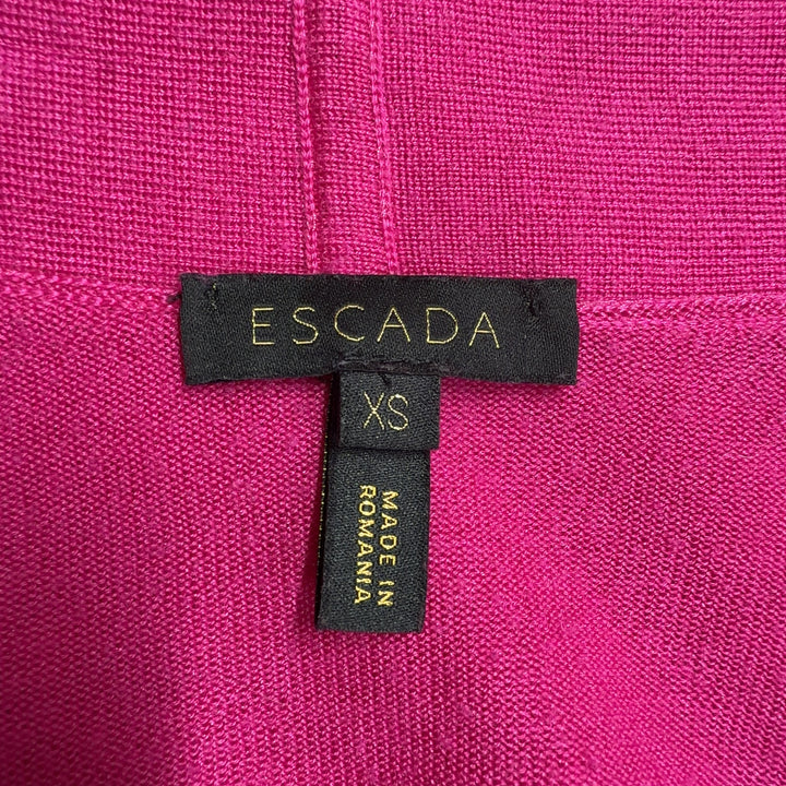 Tag view of pink ESCADA cardigan with long sleeves and flowing silhouette, styled with black pants