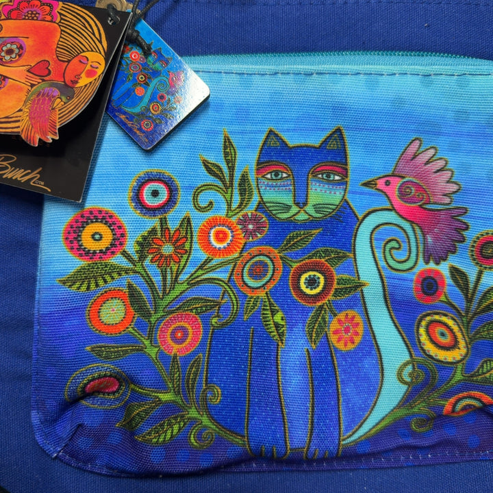 Tag view of blue canvas crossbody bag worn on shoulder showing adjustable light blue straps