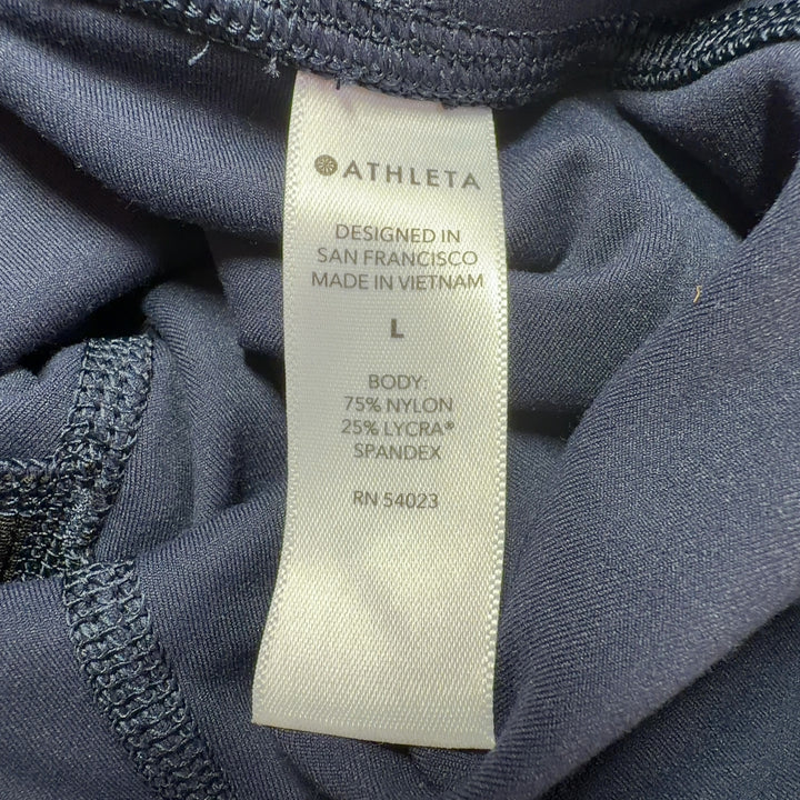 Black Athleta capri leggings back view, displaying high-waisted silhouette and supportive fit