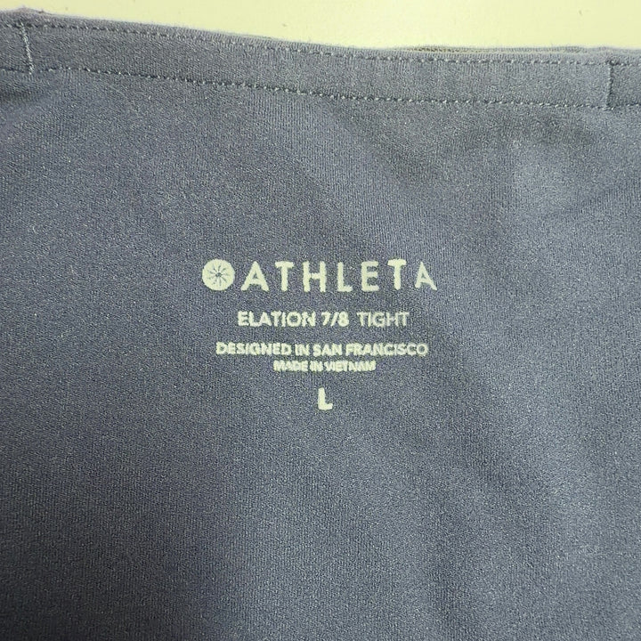 Black Athleta capri leggings back view, displaying high-waisted silhouette and supportive fit