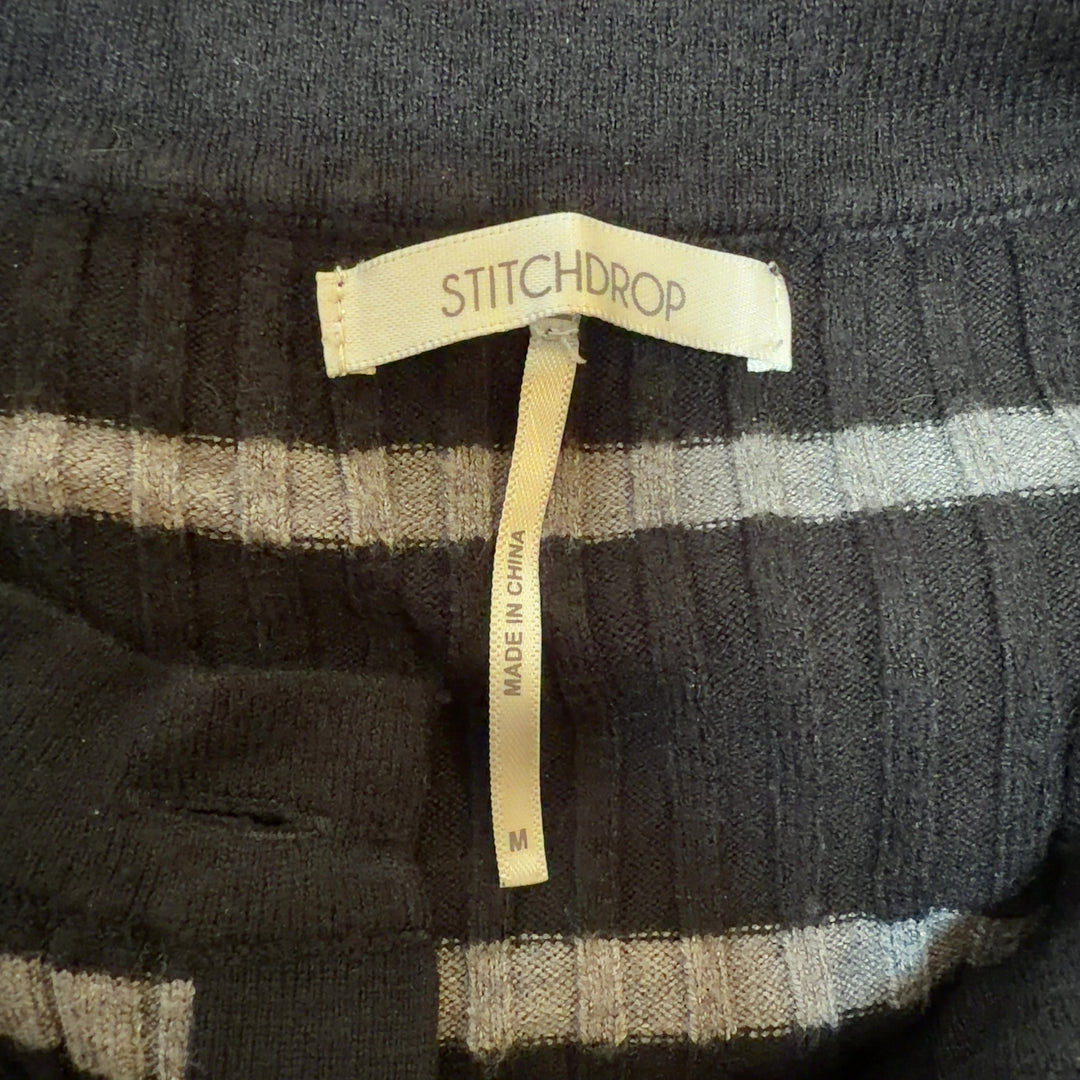 Tag view of black striped crop cardigan showing horizontal stripe pattern and fitted silhouette