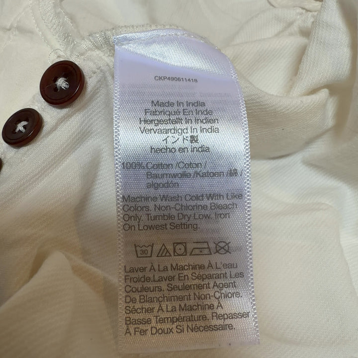 Cream cotton button-front shirt dress by Madewell, back view displaying oversized silhouette and midi length