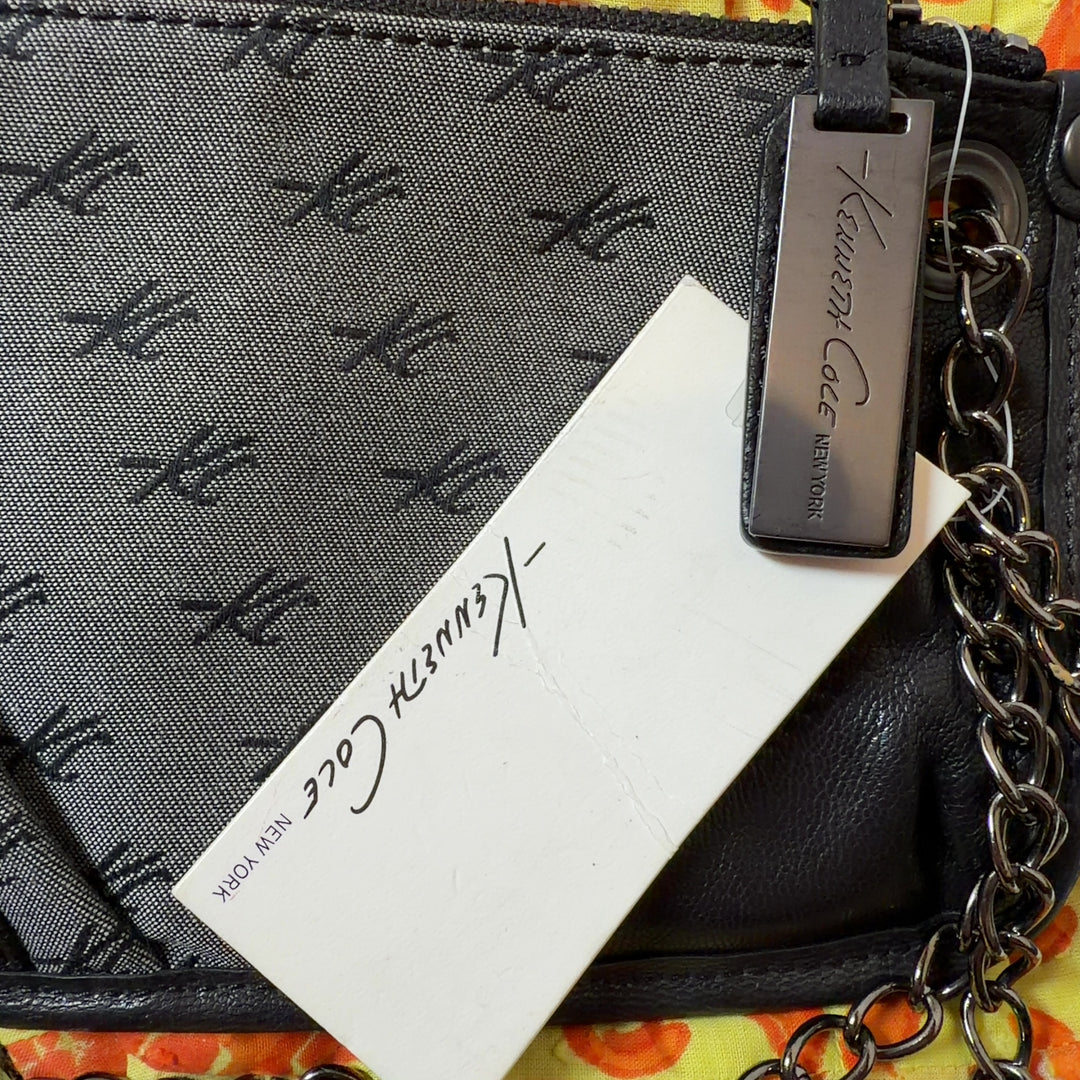 Black quilted shoulder bag with silver chain strap worn as crossbody bag, back view on model