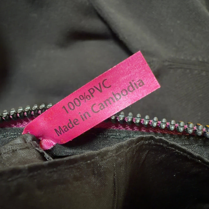 Pink PVC clutch styled as wearable wristlet accessory with zipper pocket detail
