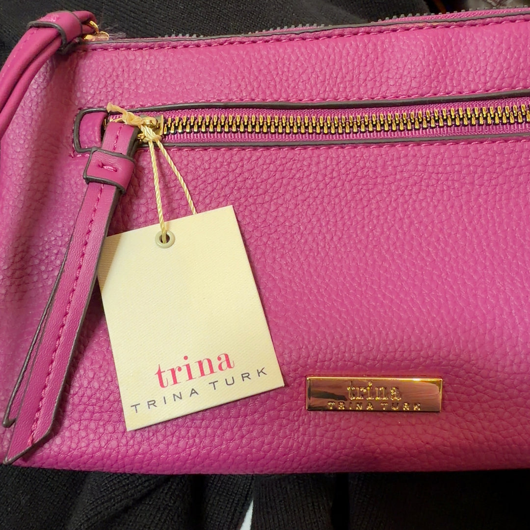 Pink PVC clutch styled as wearable wristlet accessory with zipper pocket detail