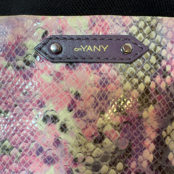 Pink python print orYANY clutch with chain strap styled with black outfit